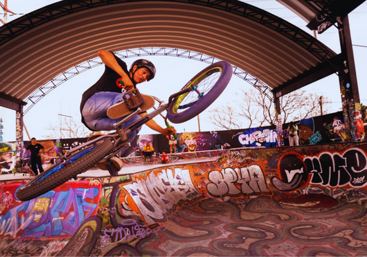 BMX rider mid-air at a skate park — pure movement